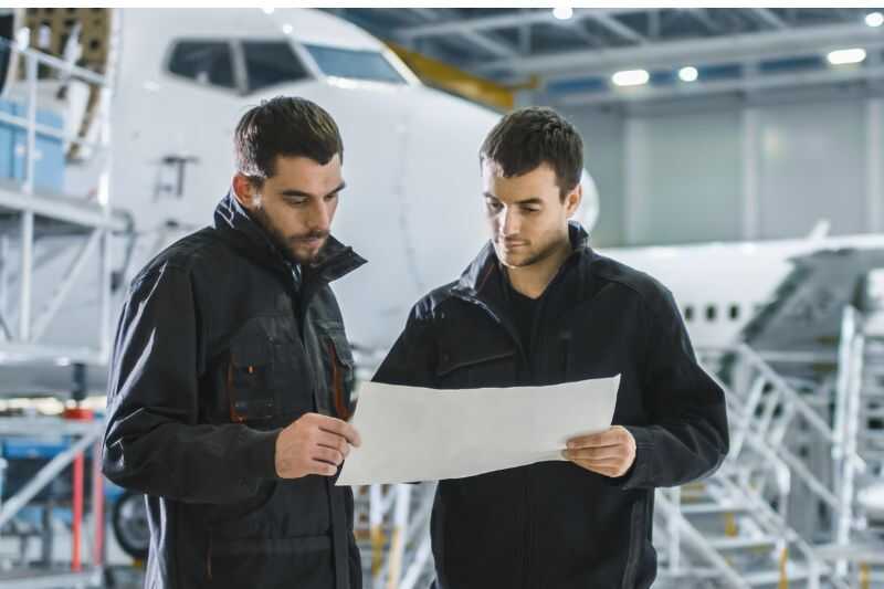 Engineers Looking At Aircraft Plans In A Hanger