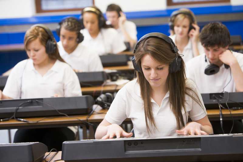 A Teen Playing The Keyboard In Music Class