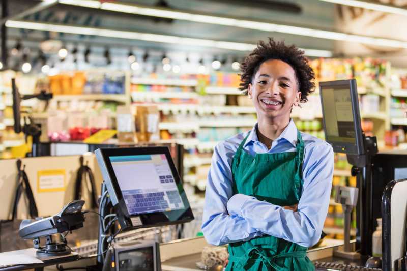 A Young Supermarket Cashier At The Checkout