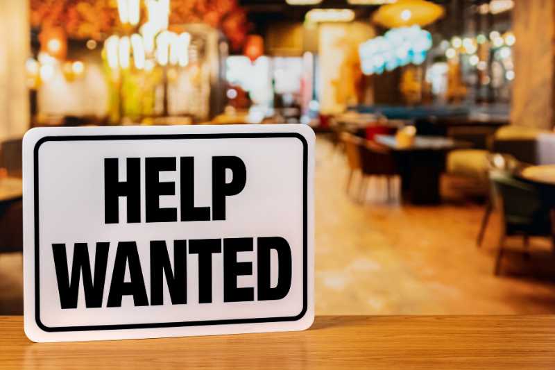 A Help Wanted Sign In A Restaurant Window