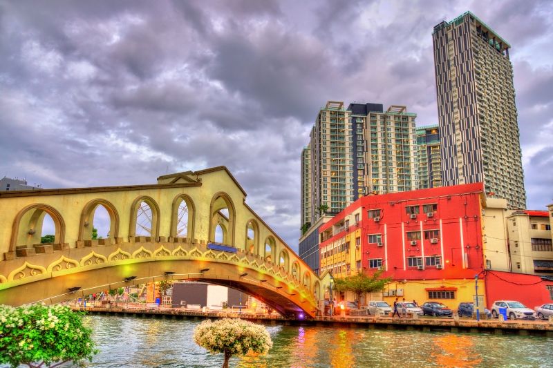 A Skyscraper In Asia Towering Over A Traditional Bridge